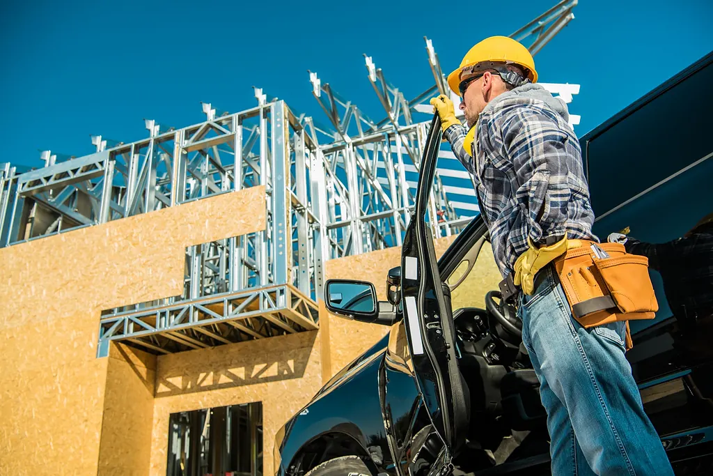 Bauarbeiter mit Helm und Werkzeuggürtel auf einer Baustelle
